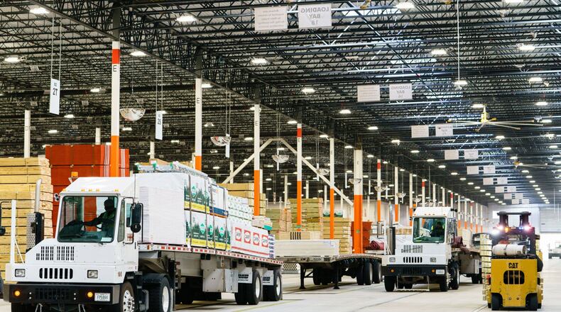 A driver prepares to pull a flatbed trailer out of a Home Depot Flatbed Distribution Center in Lithonia. Home Depot recorded record earnings on the back of th strength of the housing renocation market. Bloomberg photo by Elijah Nouvalege.