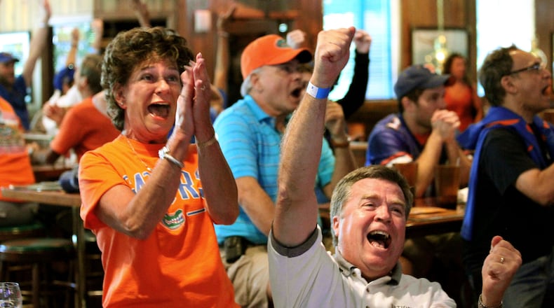 University of Florida fans Patt and Kent Lytle, of Cumming, celebrate Florida's final touchdown during their game against University of Miami (Ohio) on television at Miller Ale House Saturday afternoon in Alpharetta in this 2010 file photo.