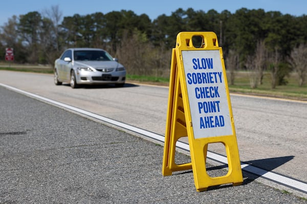 A vehicle slows for a license check and sobriety checkpoint off an exit on I-16 in Twiggs County, southeast of Macon, on Saturday, March 14, 2026. (Arvin Temkar/AJC)