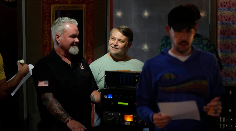 Army veterans David Booth, left, and Clay Jensen, center, watch as musicians and sound technicians prepare to record a song based on their military experiences on Wednesday, Sept. 9, 2025, in Nashville, Tenn. (AP Photo/Mark Humphrey)