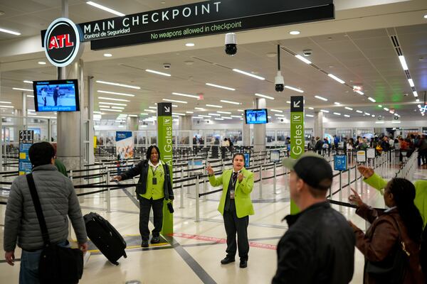 Airport workers help travelers navigate through Hartsfield-Jackson Atlanta International Airport on Friday, Nov. 7, 2025, as flight cuts take effect amid the federal government shutdown. (Ben Hendren for the AJC)