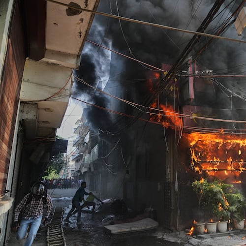 Local people attempt to douse a fire at a hotel in New Delhi, India, Wednesday, June 3, 2026. (AP Photo/Manish Swarup)