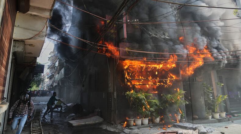Local people attempt to douse a fire at a hotel in New Delhi, India, Wednesday, June 3, 2026. (AP Photo/Manish Swarup)