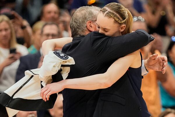 UConn guard Paige Bueckers (5) hugs UConn head coach Geno Auriemma as she comes off the floor late in the second half of the national championship game against South Carolina at the Final Four of the women's NCAA college basketball tournament, Sunday, April 6, 2025, in Tampa, Fla. (AP Photo/John Raoux)