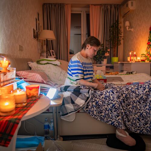 Kyiv resident Olena Janchuk, 53, who can no longer walk due to illness, endures a blackout in her apartment with her mother, keeping warm with candles and heated bricks after Russian attacks on Ukraine's energy infrastructure in Kyiv, Ukraine, Tuesday, Jan. 20, 2026. (AP Photo/Dan Bashakov)