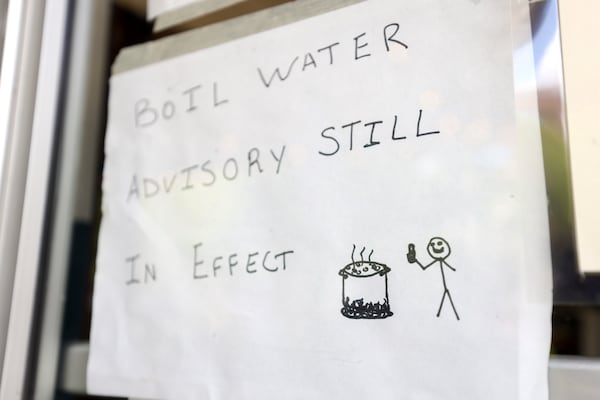 A sign reads, “Boil Water Advisory Still in Effect,” with a drawing of water being boiled and a stick figure with a thumbs up at the main entrance to the restaurant, Sun in my Belly, in the Kirkwood neighborhood, Monday, June 3, 2024, in Atlanta. (Jason Getz / AJC)
