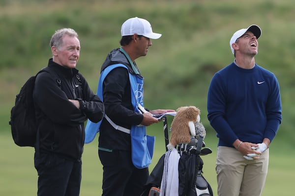 Rory McIlroy of Northern Ireland, right laughs, with caddy Harry Diamond, center, on the 11th fairway during a practice round for the 2025 British Open golf championship at the Royal Portrush Golf Club, Northern Ireland, Monday, July 14, 2025. (AP Photo/Peter Morrison)
