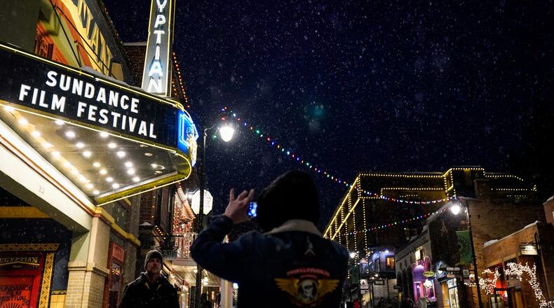 People take photos beneath the marquee of the Egyptian Theater during the Sundance Film Festival on Jan. 22, 2020, in Park City, Utah. (Kent Nishimura/Los Angeles Times/TNS)