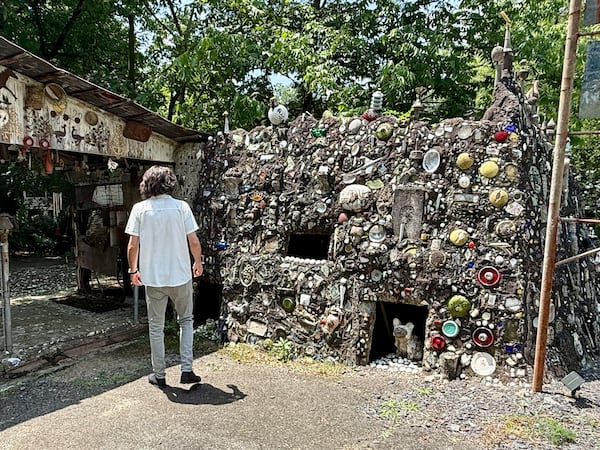 A visitor to Paradise Garden on June 21, 2005 admires the variety of curios cemented into a wall by Howard Finster. Danielle Charbonneau/AJC