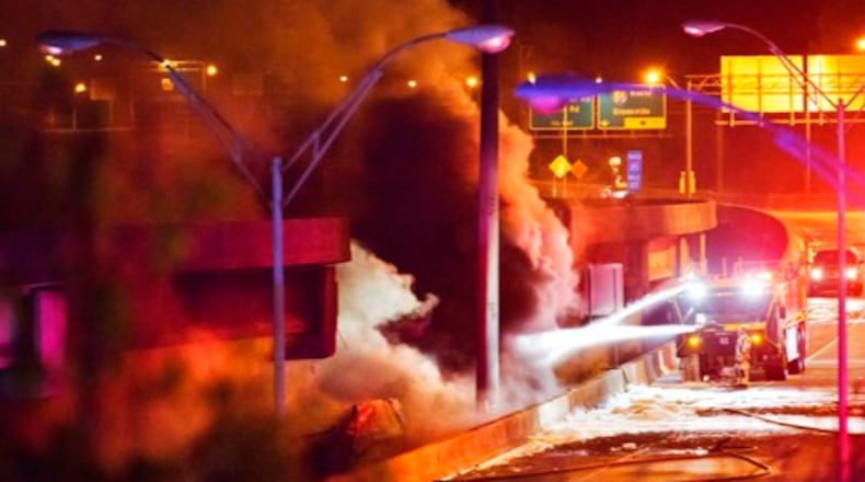 Smoke billows from a section of an overpass that collapsed from a large fire on Interstate 85 in Atlanta, Thursday, March 30, 2017. Witnesses say troopers were telling cars to turn around on the bridge because they were concerned about its integrity. Minutes later, the bridge collapsed. (AP Photo/David Goldman)