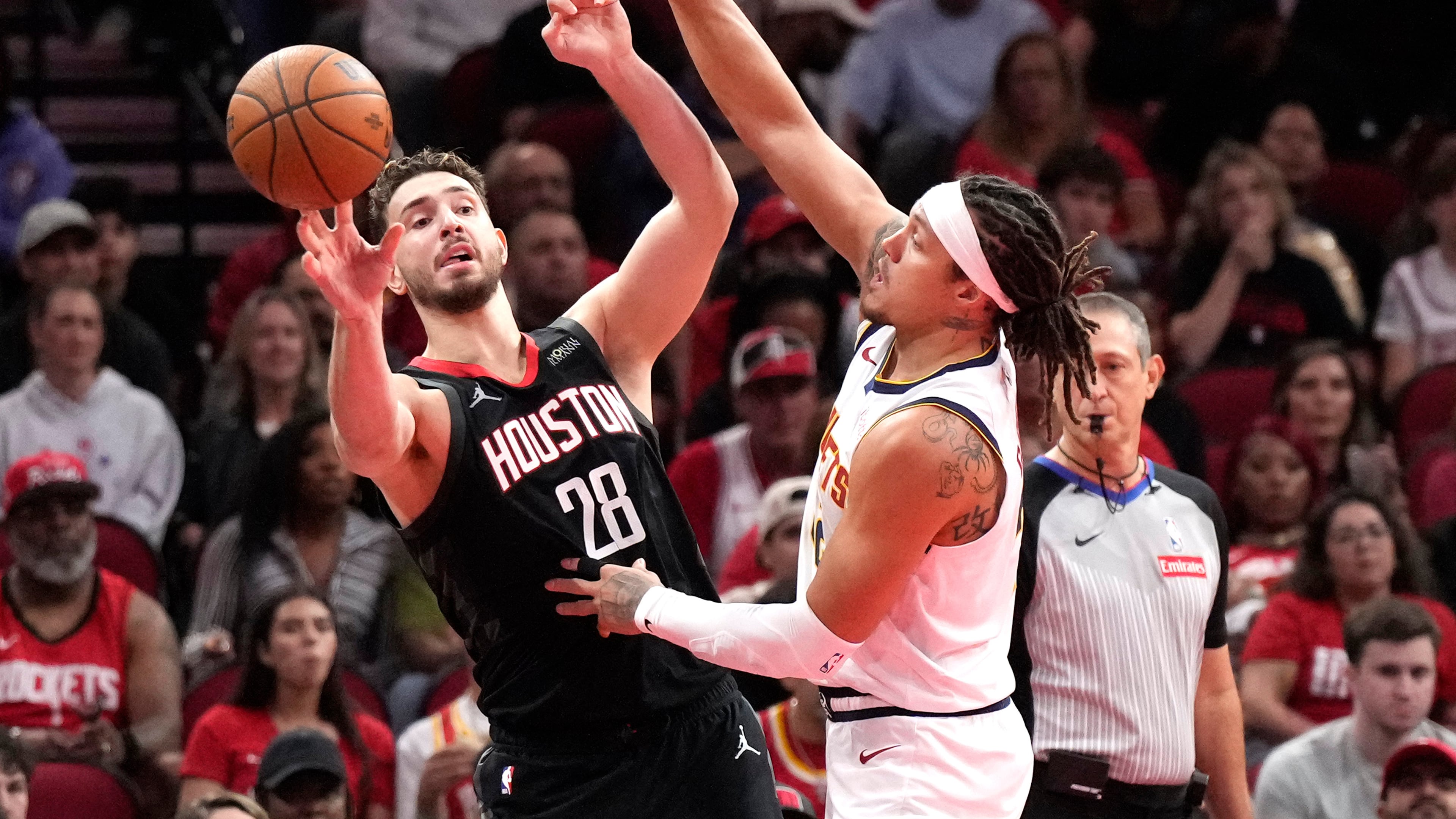 Houston Rockets center Alperen Sengun (28) passes the ball against Denver Nuggets forward Aaron Gordon during the first half of an NBA Cup basketball game, Friday, Nov. 21, 2025, in Houston. (AP Photo/Karen Warren)