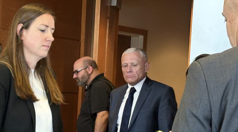 This photo taken with a smartphone shows defense attorney Delia McCarthy, left, and Jeffrey Buskey, center, charged with multiple counts of aggravated felonious sexual assault, leaving a courtroom during a break in Buskey's trial in Manchester, N.H., Monday, Sept. 14, 2026. (AP Photo/Holly Ramer)