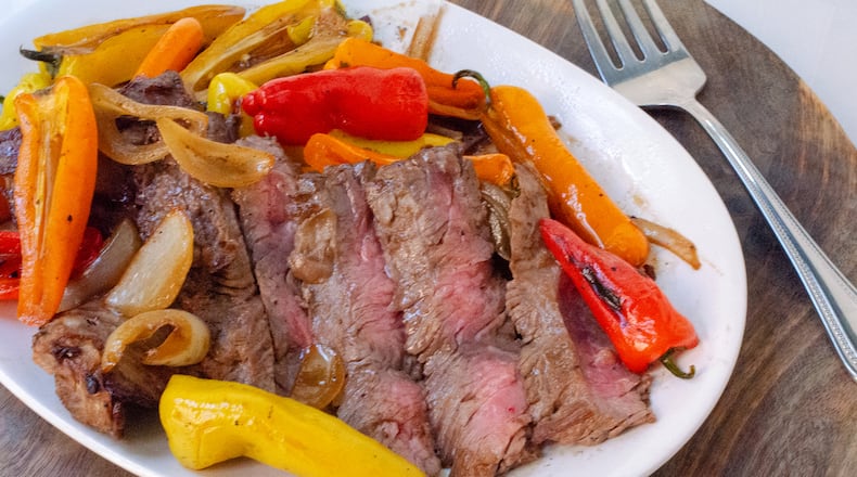 A platter of sliced skirt steak with peppers, onions and garlic in teriyaki sauce is a quick dish that's also easy on your pocketbook.
(Virginia Willis for The Atlanta Journal-Constitution)
