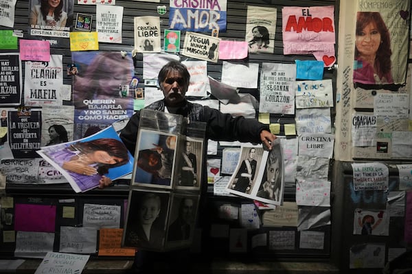 A vendor hawks pictures of former President Cristina Fernandez outside her home, after a federal court granted her request to serve a six-year prison sentence for corruption at her home, in Buenos Aires, Argentina, Tuesday, June 17, 2025. (AP Photo/Natacha Pisarenko)
