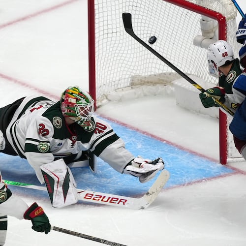 Minnesota Wild goaltender Jesper Wallstedt, center, misses a goal shot by Colorado Avalanche defenseman Brett Kulak as Minnesota right wing Mats Zuccarello, left, and defenseman Jared Spurgeon cover in overtime of Game 5 of an NHL Stanley Cup hockey second-round playoff series Wednesday, May 13, 2026, in Denver. (AP Photo/David Zalubowski)