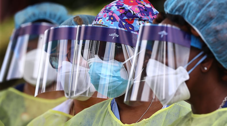 FILE - In this May 4, 2020, file photo, volunteers line up to begin taking hundreds of free COVID-19 tests at a pop-up site at the House of Hope in Decatur, Ga. Many African Americans watching protests calling for easing restrictions meant to slow the spread of the new coronavirus see them as one more example of how their health, their safety and their rights just don't seem to matter. (Curtis Compton/Atlanta Journal-Constitution via AP, File)