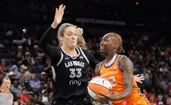 Connecticut Sun guard Saniya Rivers (22) drives to the basket against Las Vegas Aces center Elizabeth Kitley (33) during the first half of a WNBA basketball game Wednesday, June 25, 2025, in Las Vegas. (Steve Marcus/Las Vegas Sun via AP)
