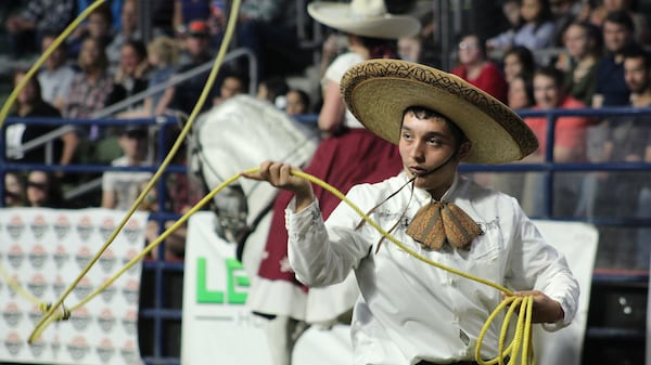 A performer with Rancho Los Lagos prepares to jump through his lasso as Mariachi Azteca plays and riders guide their horses in choreography in Wenatchee, Wash. (Crystal Paul/Seattle Times/TNS)