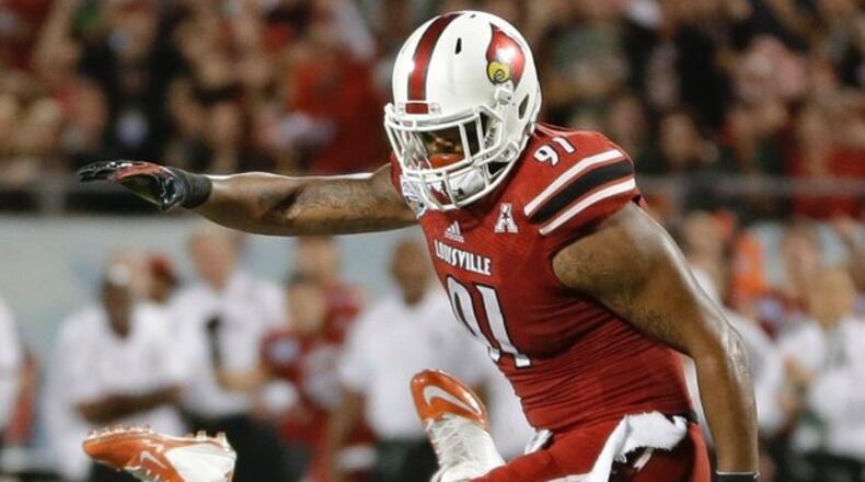 Photo: AP Miami quarterback Stephen Morris, lower left, fumbles the ball as he is hit by Louisville defensive end Marcus Smith (91) during the first half of the Russell Athletic Bowl NCAA college football game in Orlando, Fla.,