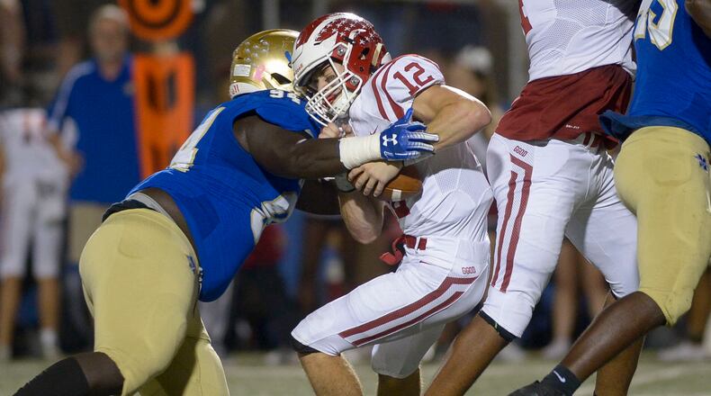 Cobb County rivals square off: McEachern defensive linebacker Anthony Harris (94) sacks Hillgrove quarterback Matthew McCravy (12) in the first half of Friday's game at McEachern. (Daniel Varnado/Special)
