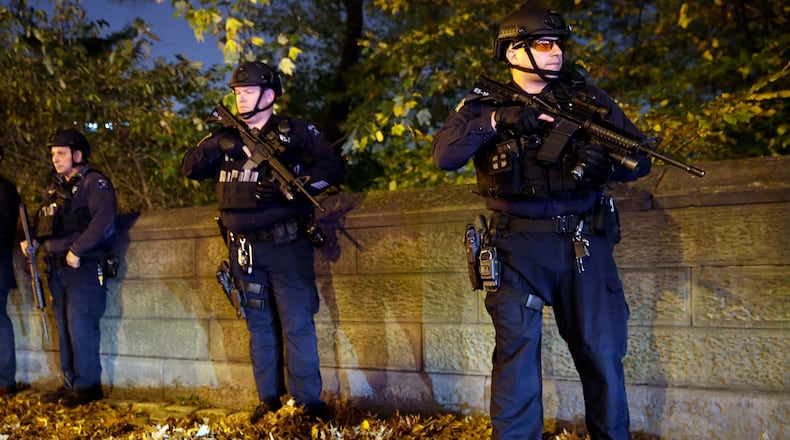 Heavily armed New York City police officers stand guard across the street from the French consulate on New York's Fifth Ave., Friday, Nov. 13, 2015. Police in New York say they've deployed extra units to crowded areas of the city "out of an abundance of caution" in the wake of the attacks in Paris, France. A New York Police Department statement released Friday stressed police have "no indication that the attack has any nexus to New York City." (AP Photo/Mary Altaffer)
