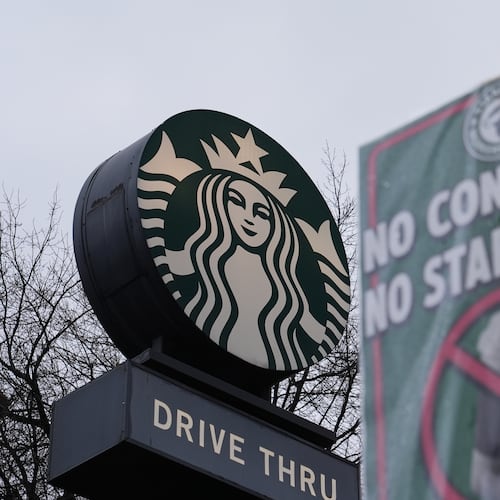 The Starbucks logo is seen as workers strike outside a store Thursday, Nov. 13, 2025, in Seattle. (AP Photo/Lindsey Wasson)