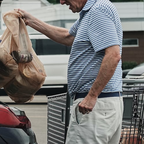FILE - A person loads groceries in plastic bags into their vehicle, May 18, 2026, at a grocery store in Cincinnati. (AP Photo/Joshua A. Bickel, File)