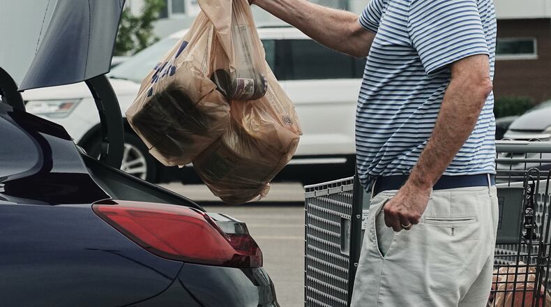 FILE - A person loads groceries in plastic bags into their vehicle, May 18, 2026, at a grocery store in Cincinnati. (AP Photo/Joshua A. Bickel, File)