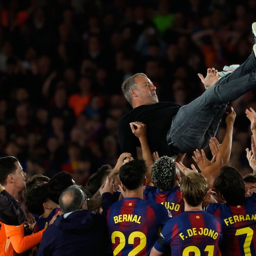 Barcelona head coach Hansi Flick is lifted by his players after winning the Spanish La Liga soccer match against Real Madrid to clinch the Spanish league title in Barcelona, Spain, Sunday, May 10, 2026. (AP Photo/Joan Monfort)