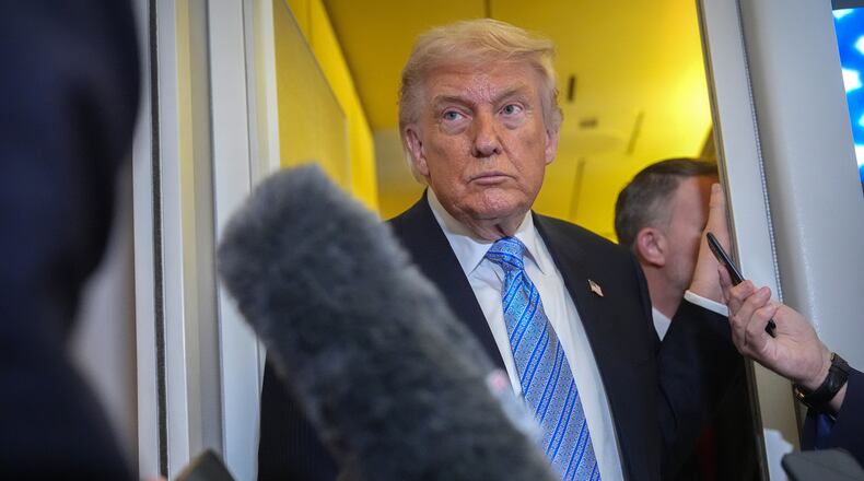 President Donald Trump speaks to reporters aboard Air Force One, Friday, May 15, 2026, as he returns from a trip to Beijing, China. (AP Photo/Mark Schiefelbein)