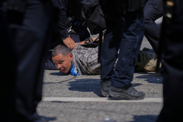 A protester is detained by police in downtown Los Angeles, Sunday, June 8, 2025, following last night's immigration raid protest. (AP Photo/Eric Thayer)
