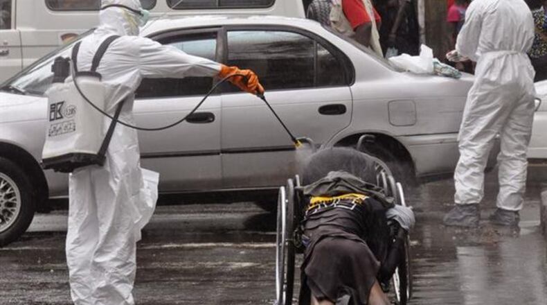 Health workers disinfect the body of a person suspected of dying from the Ebola virus on Sept. 2 in Monrovia, Liberia. (AP Photo)