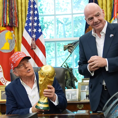 FILE - President Donald Trump holds the FIFA World Cup Winners Trophy as FIFA President Gianni Infantino looks on during an announcement in the Oval Office of the White House, Aug. 22, 2025, in Washington. (AP Photo/Jacquelyn Martin, File)