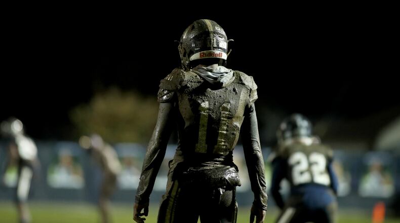 Covered in mud, Marietta free safety Rashun Bass (11) prepares to return a kick off in the first half of Friday's game against East Coweta. (Jason Getz/Special)