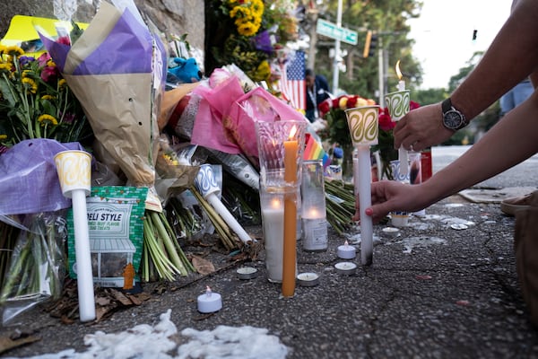 In the days following the incident, people left flowers and candles at the Piedmont Park entrance. (Ben Gray for the AJC)