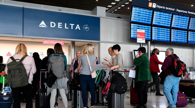 Travellers queue at a Delta Airlines desk at Paris-Charles-de-Gaulle airport in Roissy-en-France on March 12, 2020.  (Bertrand Guay/AFP via Getty Images/TNS)