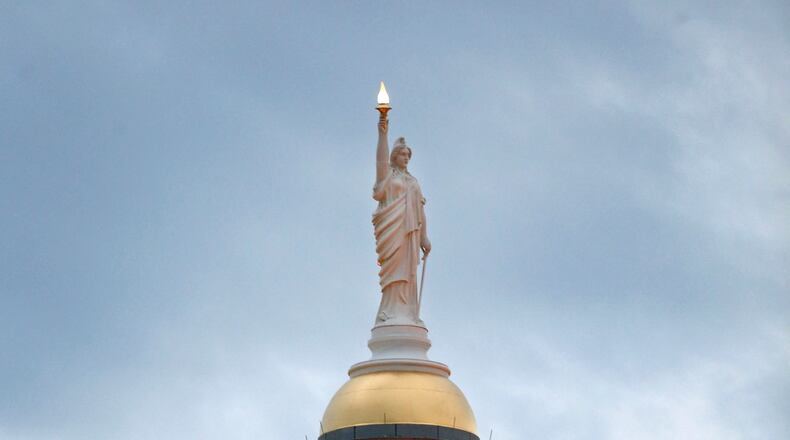January 9, 2013 - Atlanta, Ga: The statue Miss Freedom sits atop of the gold dome of the Georgia State Capitol at dusk Wednesday evening in Atlanta, Ga., January 9, 2013. The Georgia Capitol completed in 1889, is only days away from the start of the 2013 Legislative Session in the House and Senate Chambers Monday January 14, 2013. JASON GETZ / JGETZ@AJC.COM The governor is scheduled to sign 10 education bills Thursday, but campus carry is not on the list. (AJC Photo.)