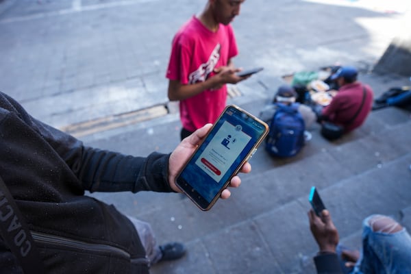 FILE - Venezuelan migrant Yender Romero shows the U.S. Customs and Border Protection (CBP) One app on his cell phone at a migrant tent camp outside La Soledad church in Mexico City on Jan. 20, 2025. (AP Photo/Fernando Llano, File)