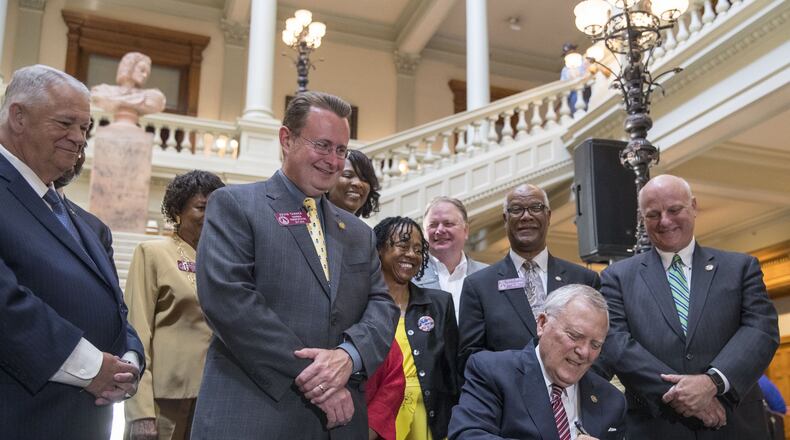 Georgia Governor Nathan Deal signs House Bill 930 at the Georgia State Capitol Thursday. The law allows 13 local counties to raise sales taxes for mass transit, if their voters consent. Gwinnett and Fulton counties already are planning votes. DeKalb and Cobb could be next. ALYSSA POINTER/ALYSSA.POINTER@AJC.COM