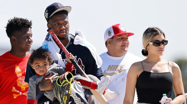 Atlanta Braves outfielder Ronald Acuna carries his son Ronald Acuna Jr. II after he finishes up practice for the day and leaves with his partner Maria Laborde (right) during Spring Training on Thursday, March 17, 2022, in North Port.    “Curtis Compton / Curtis.Compton@ajc.com”