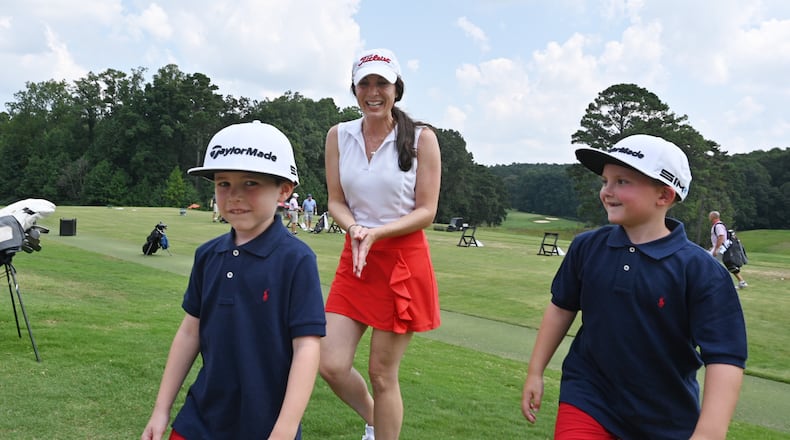 Ashley Siller, widow of Gene Siller, rounds up sons Banks (left), 5, and Beau, 7, during Tuesday's memorial tournament for her husband, murdered while at work at Pinetree Country Club in July. (Hyosub Shin / Hyosub.Shin@ajc.com)