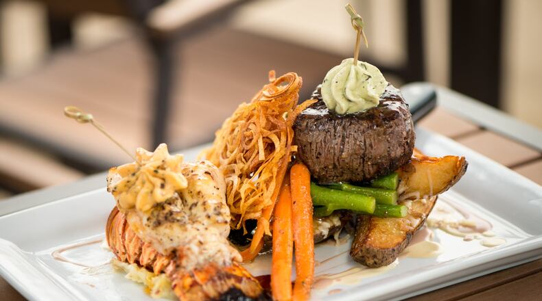 A Sage Woodfire Tavern classic is Surf & Turf with black angus petite filet, Maine lobster tail, hand cut steak fries, spinach, and lobster butter. Photo credit- Mia Yakel.