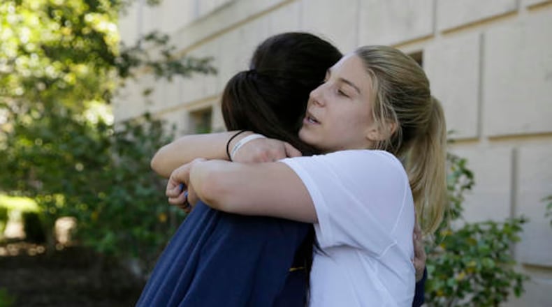 In this photo taken Tuesday, Aug. 30, 2016, Savannah Rennie, right, who underwent a liver transplant, is embraced by her best friend and teammate, Maddie Haynes, left, after volleyball practice at the University of California, Berkeley in Berkeley, Calif. Rennie returned to Cal in early August following five months in Indiana, where she received a crucial liver transplant that has allowed her slowly, somewhat impatiently to get back on the volleyball court for the Golden Bears. And she might even get in a match again by season's end, though nobody's rushing that process but Rennie herself. (AP Photo/Eric Risberg)