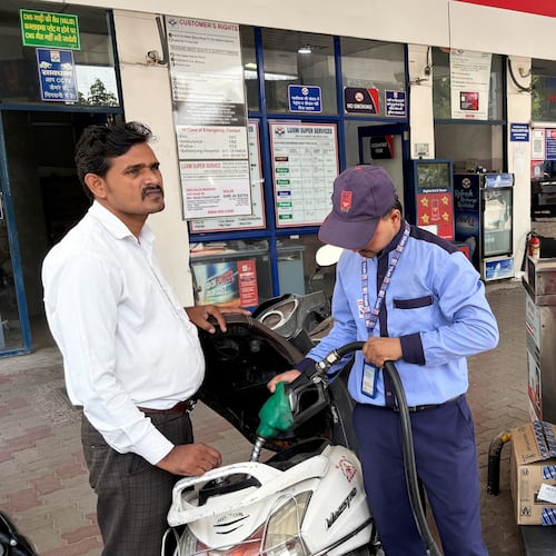 A commuter monitors the meter as an attendant refuels his scooter at a filling station in New Delhi, India, Friday, May 15, 2026. (AP Photo/Shonal Ganguly)