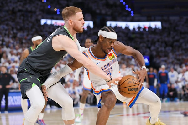 Minnesota Timberwolves guard Donte DiVincenzo, left, applies pressure on Oklahoma City Thunder guard Shai Gilgeous-Alexander during the second half of Game 1 of an NBA basketball Western Conference Finals playoff series Tuesday, May 20, 2025, in Oklahoma City. (AP Photo/Nate Billings)