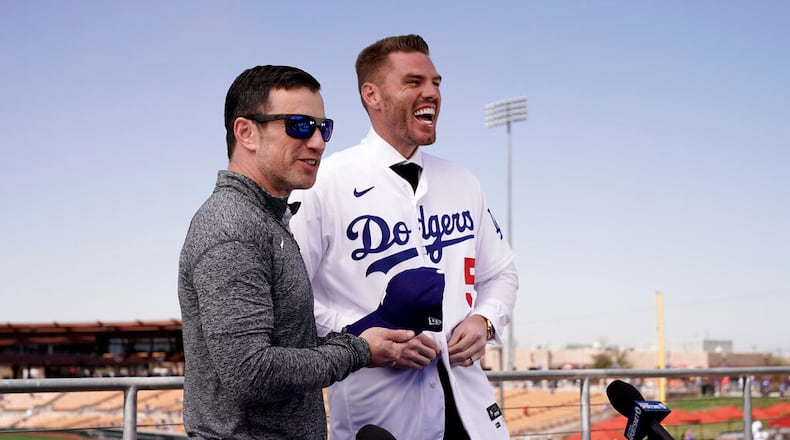 Los Angeles Dodgers president of baseball operations Andrew Friedman, left, announces the arrival of free agent Freddie Freeman during a news conference at spring training baseball, Friday, March 18, 2022, in Glendale, Ariz. (AP Photo/Charlie Riedel)