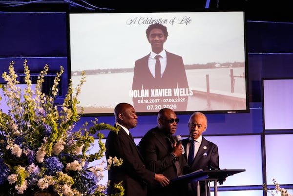 Elmore Wonsley (center) speaks next to attorney Ben Crump (left) and the Rev. Al Sharpton during a memorial service Monday, July 20, 2026, in Ocean Springs, Miss., for Nolan Xavier Wells, an 18-year-old found dead after taking a July 4 boat trip with friends. (Gerald Herbert/AP)