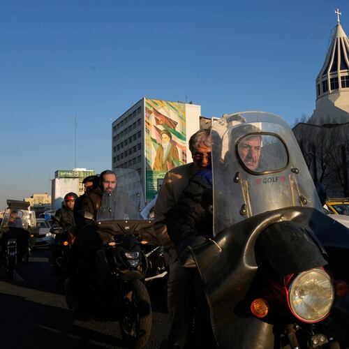 Commuters drive past Saint Sarkis church and a mural of the late Iranian revolutionary founder Ayatollah Khomeini in downtown Tehran, Iran, Wednesday, Feb. 25, 2026. (AP Photo/Vahid Salemi)