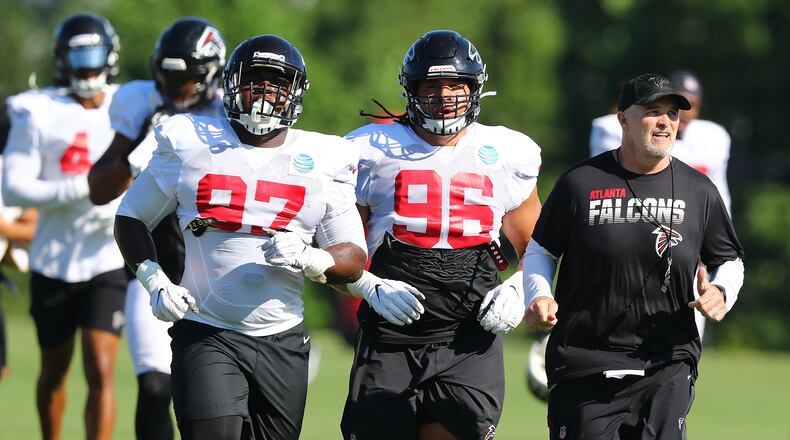 Falcons head coach Dan Quinn keeps Grady Jarrett (left), Tyeler Davison (center) and the rest of the defense on the run during the third day of training camp practice  Wednesday, July 24, 2019, in Flowery Branch.