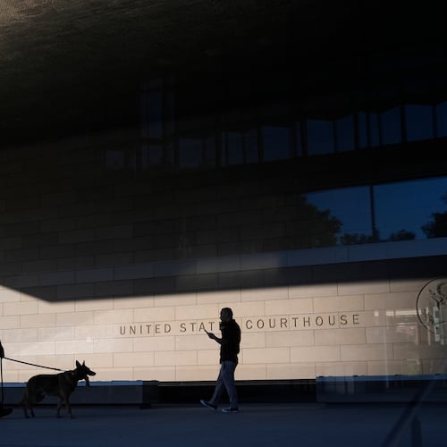 FILE - A police officer inspects the exterior of a federal courthouse with the aid of a canine on Sept. 5, 2024, in Los Angeles. (AP Photo/Jae C. Hong, File)